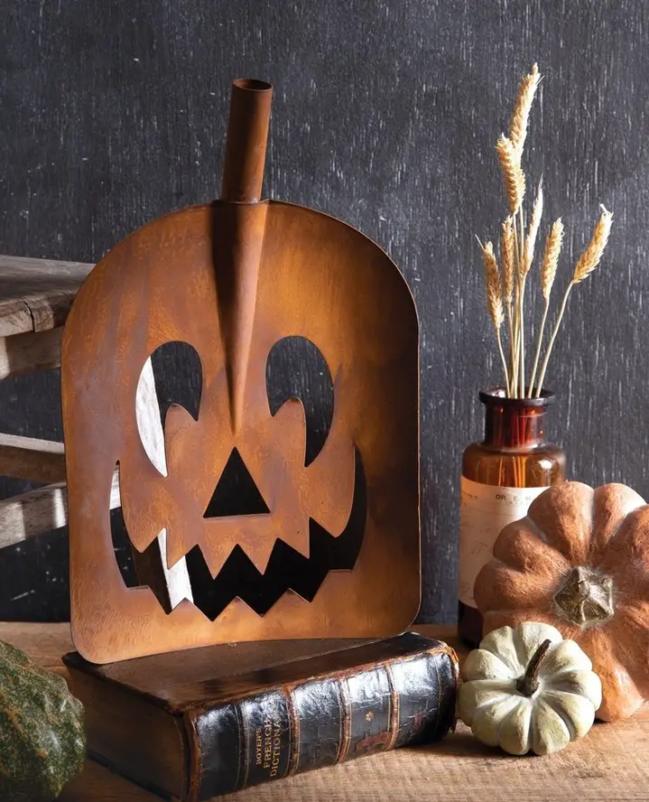Metal pumpkin lantern with books and real pumpkins.