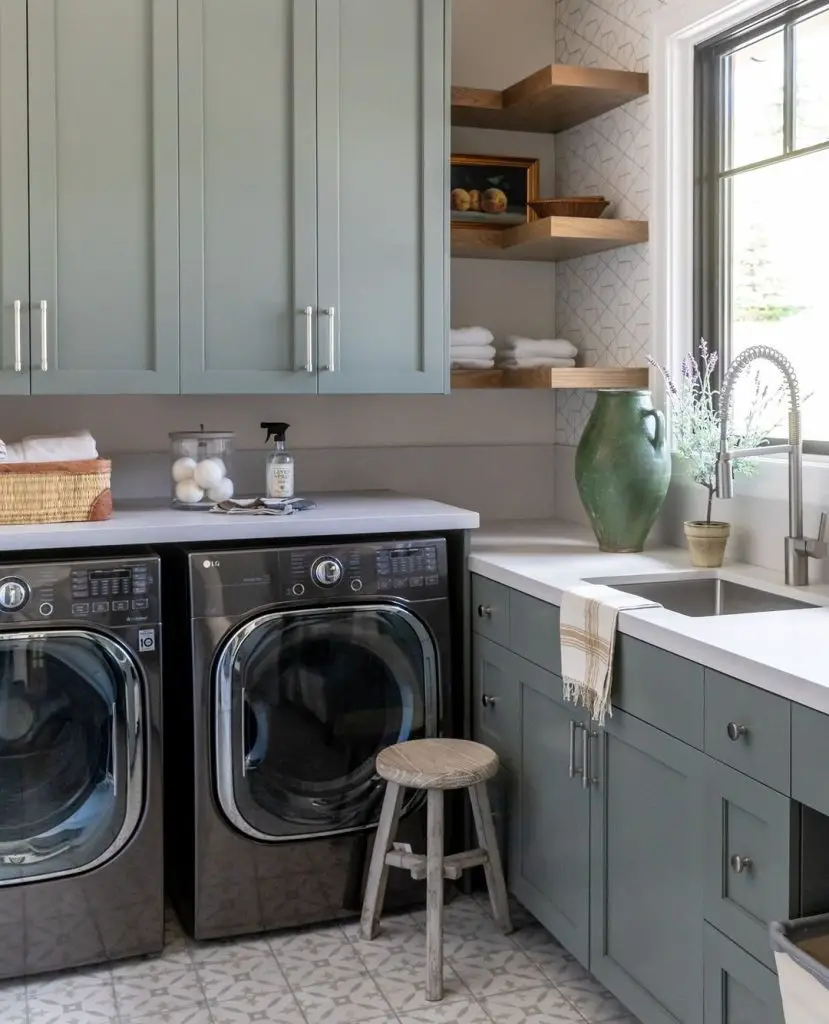 Sage green laundry room with wooden shelves and patterned floor