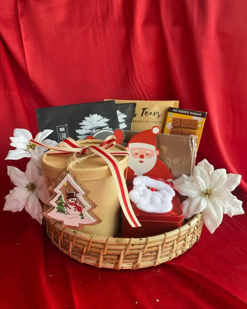 Christmas gift basket with healthy snacks and festive decorations.