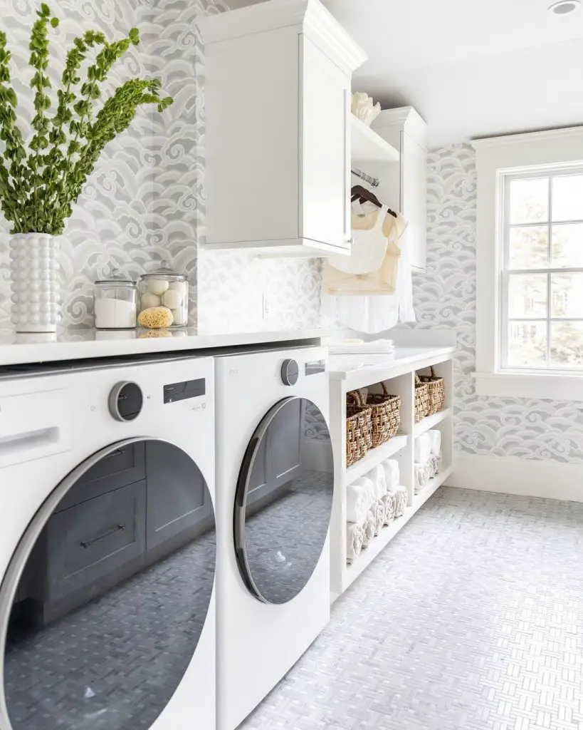 Bright laundry room with wave-patterned wallpaper and white appliances.
