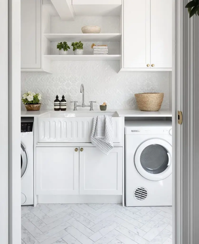Bright white laundry room with farmhouse sink and plants