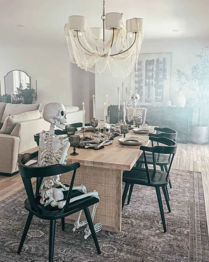 Elegant dining room with Halloween decor featuring skeleton guests and cobweb-draped chandelier