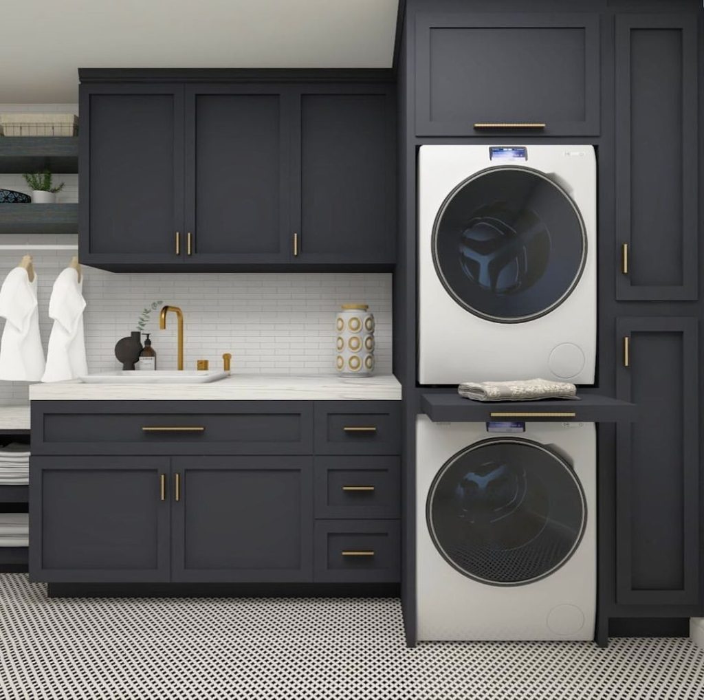Dark gray laundry room with gold accents and stacked appliances