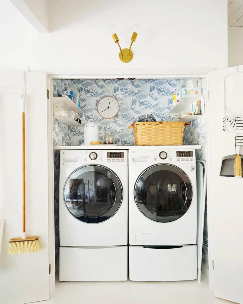 Compact laundry nook with wave-patterned wallpaper.