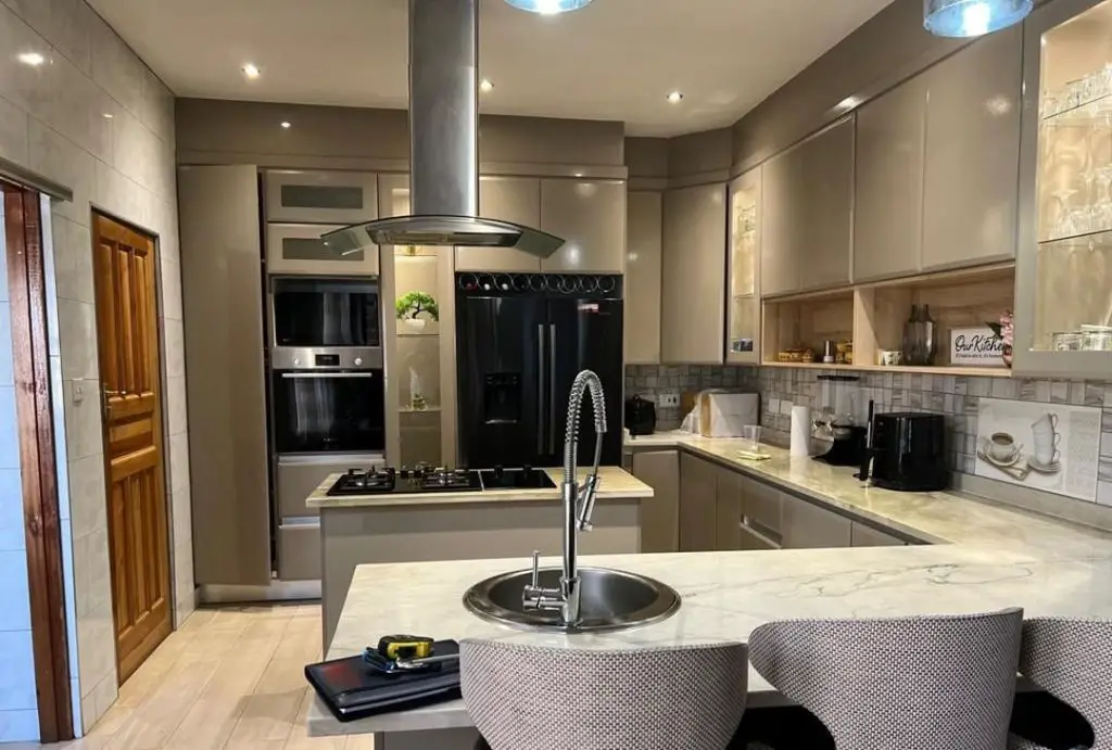 Taupe kitchen with curved island and stainless steel appliances