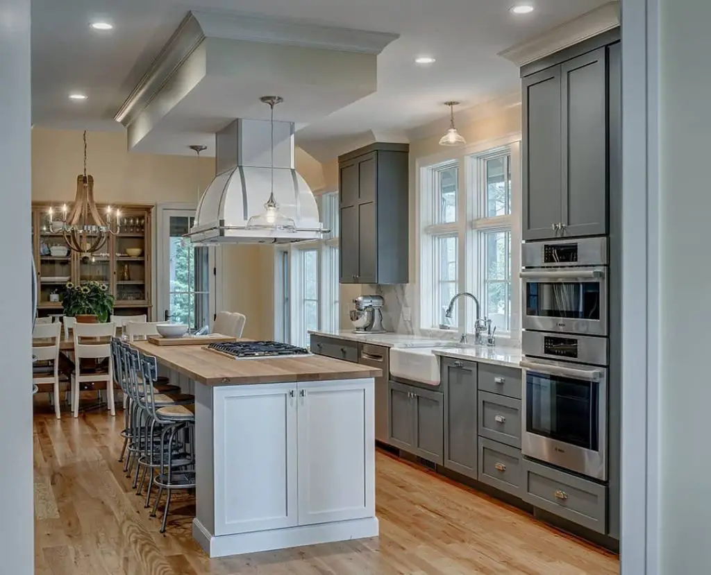 Spacious kitchen with white island, gray cabinets, and wooden floors