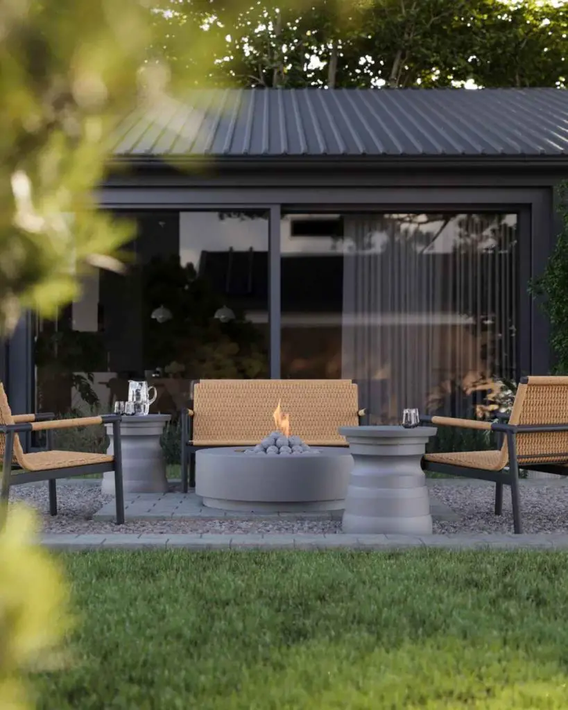 Modern outdoor seating area with fire pit near glass-walled building