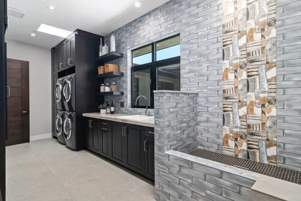 Modern laundry room with brick walls and pet wash station