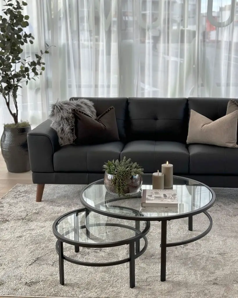 Modern living room with black sofa and glass coffee tables
