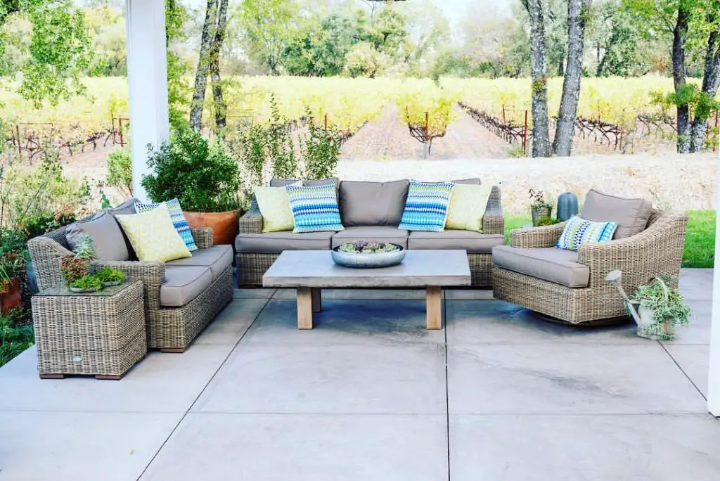 Patio with wicker furniture overlooking vineyard rows