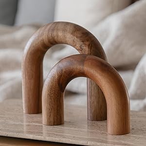 Two U-shaped wooden sculptures of different sizes are placed on a light-colored surface.