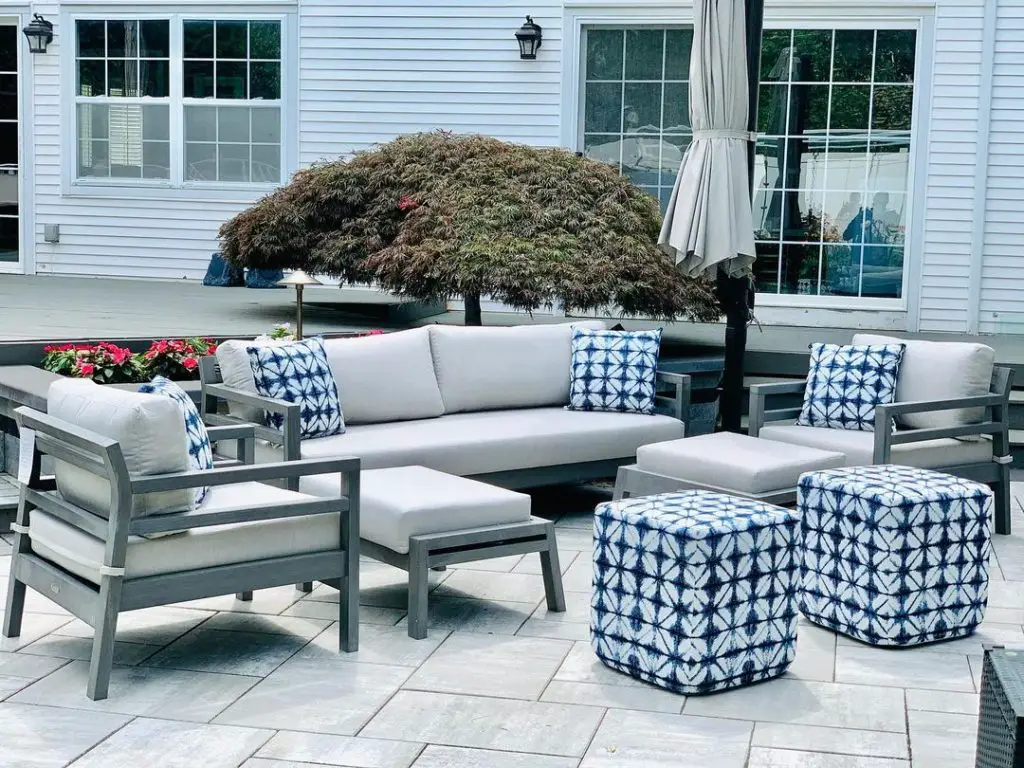 Patio with white furniture blue shibori accents and Japanese maple