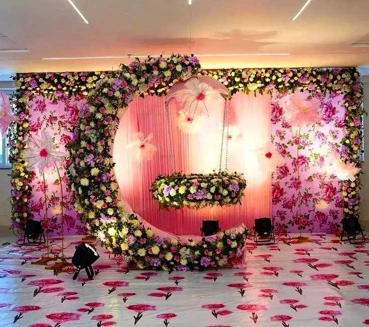 Elaborate pink floral wedding backdrop with suspended crescent arrangement