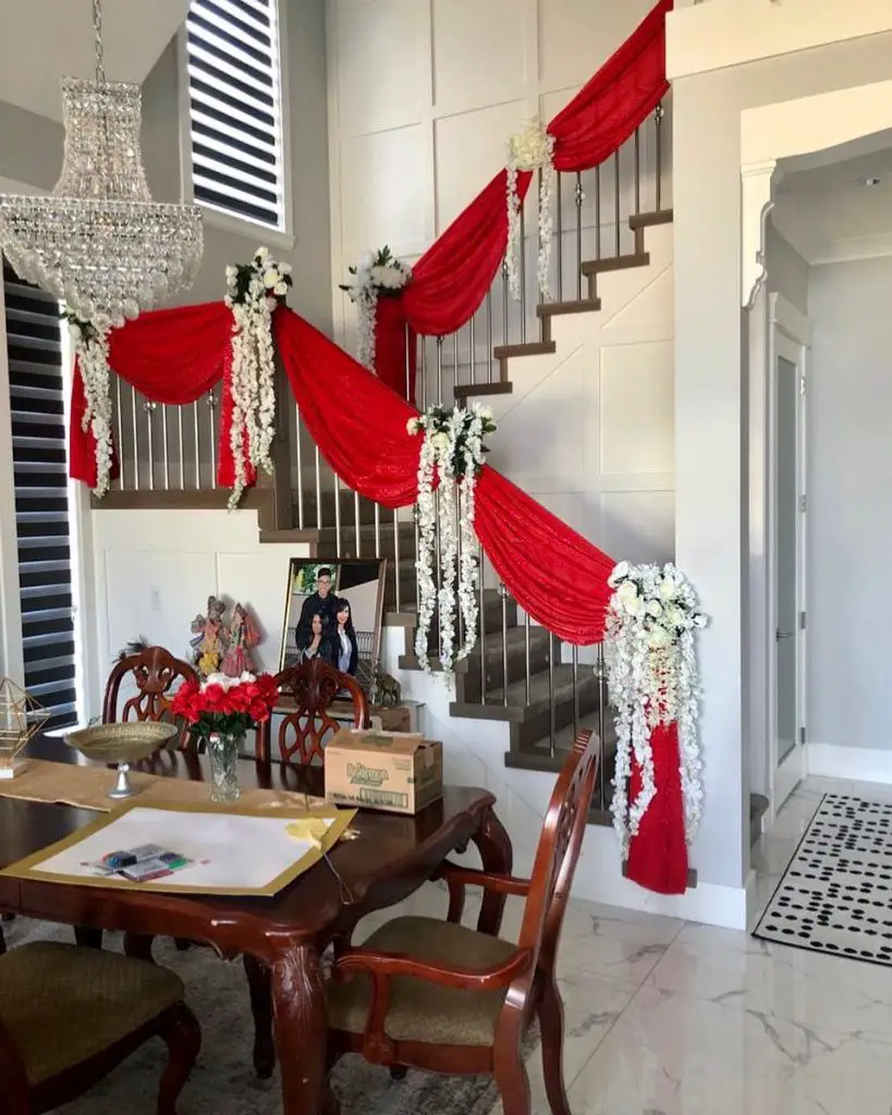 Staircase decorated with red fabric and white flowers