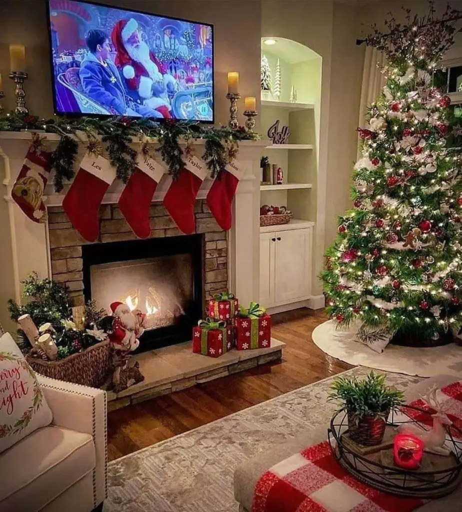 Festively decorated living room with lit Christmas tree and stockings by the fireplace