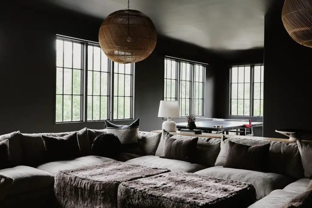 Dark living room with large cozy sectional and woven light fixtures
