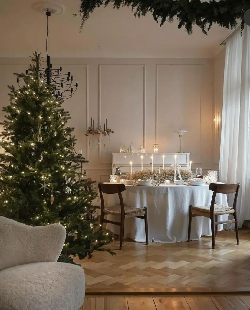 Christmas tree beside set dinner table with candles