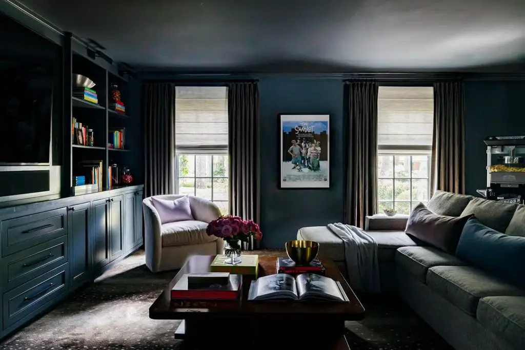 Dark blue living room with built-in shelves and movie poster.