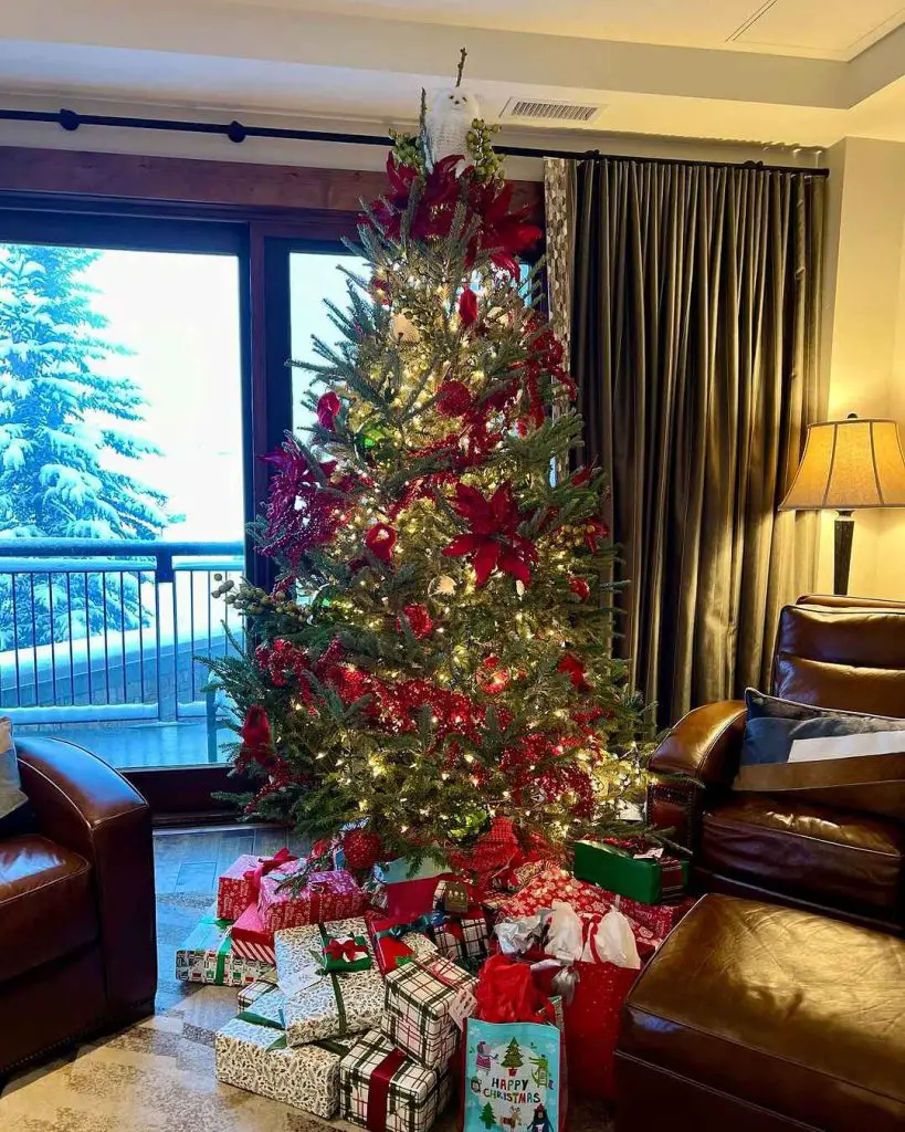Christmas tree with red decorations overlooking snowy landscape