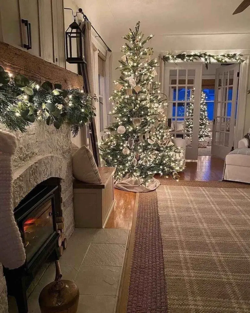 Cozy living room with lit Christmas tree and fireplace