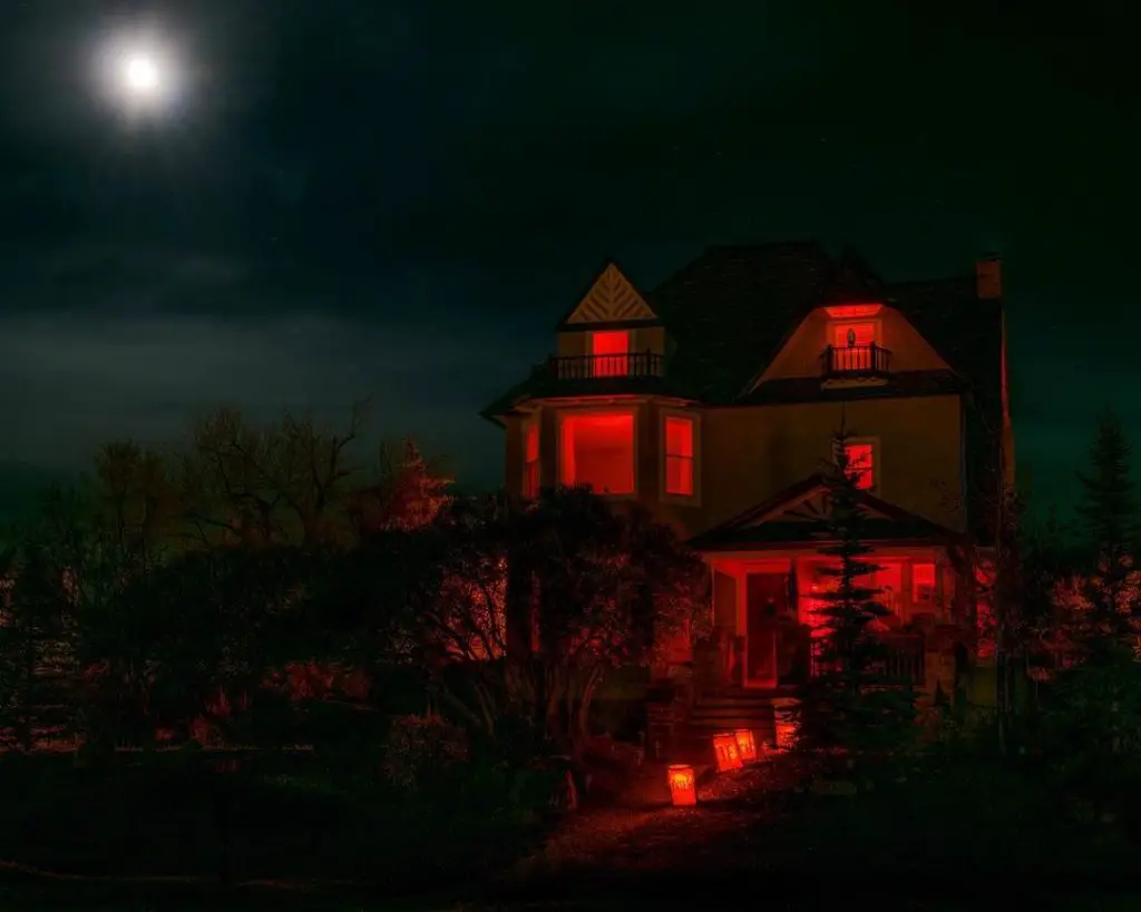 Spooky house glowing red under full moon