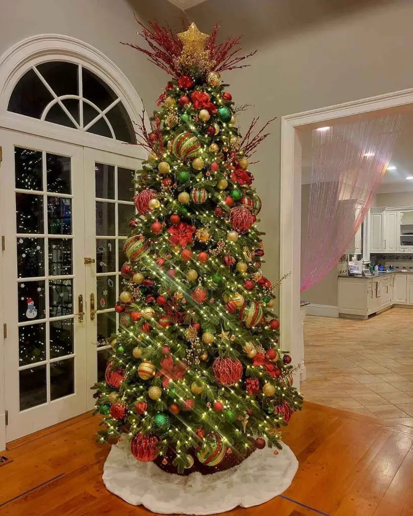 Majestic red-gold Christmas tree beside French doors