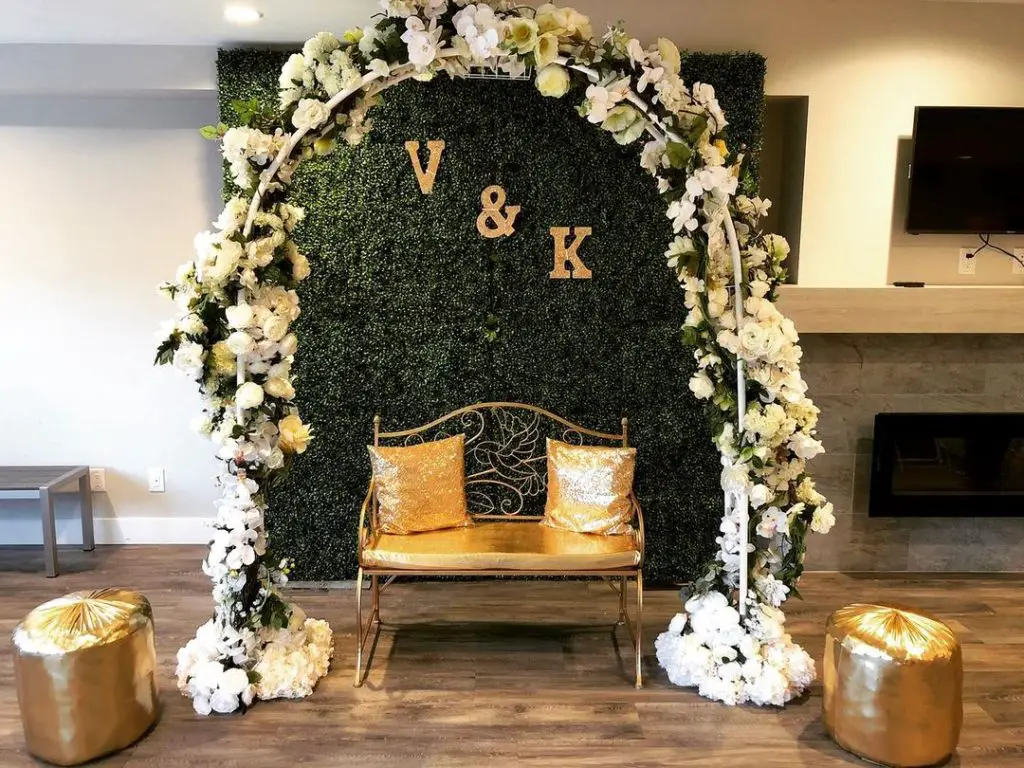 Floral arch framing green wall backdrop