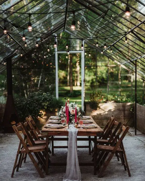 Dinner table in greenhouse with string lights