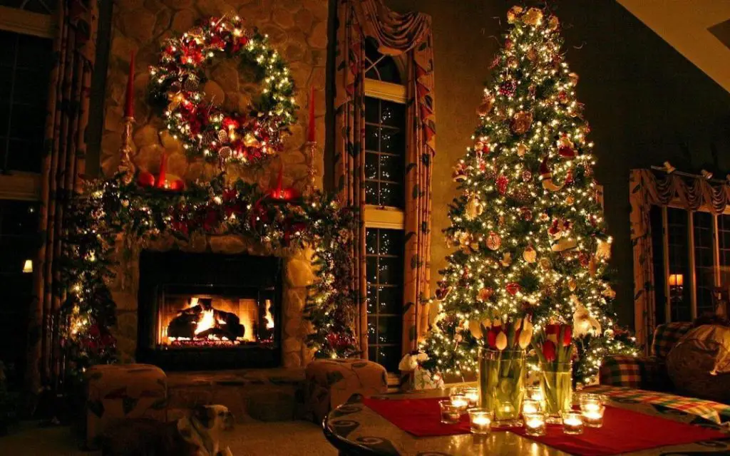 Cozy Christmas living room with illuminated tree, fireplace, and glowing candles