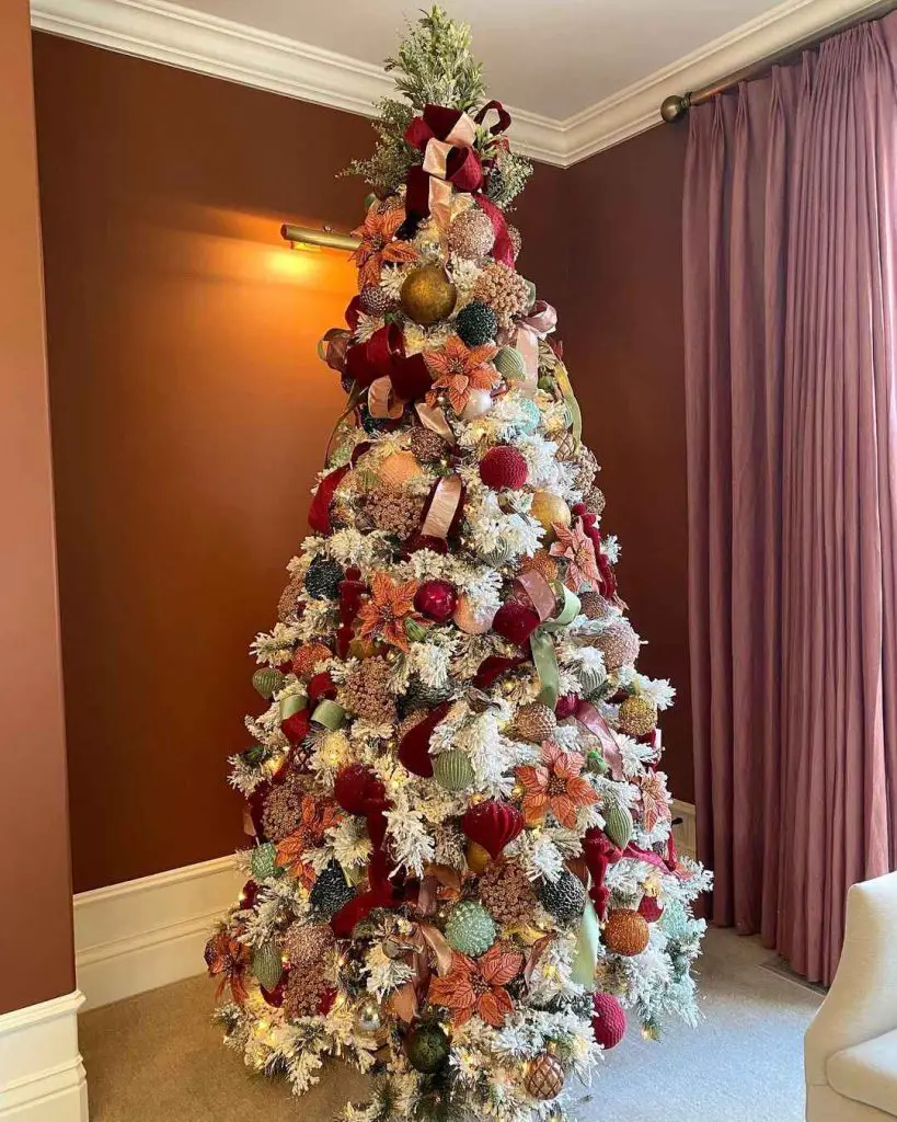 Flocked white Christmas tree with burgundy and metallic decorations