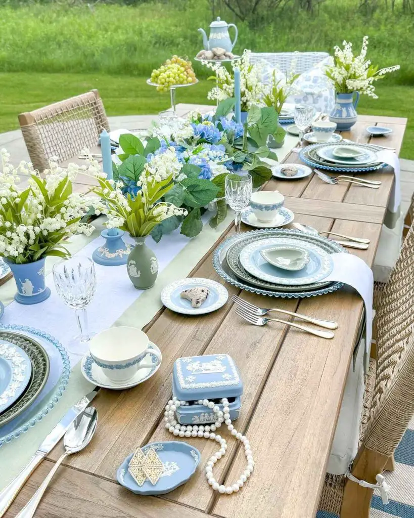 Outdoor table set with blue-white china and floral centerpiece.