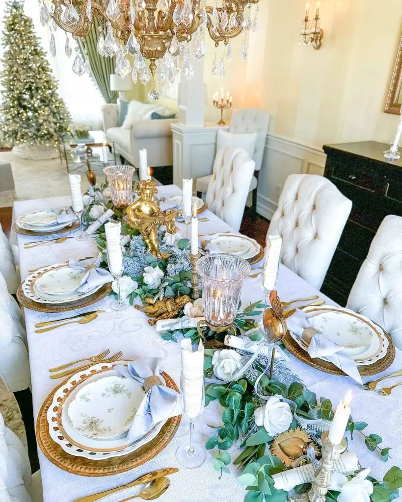 Elegant Christmas table with gold accents and cherub centerpiece.