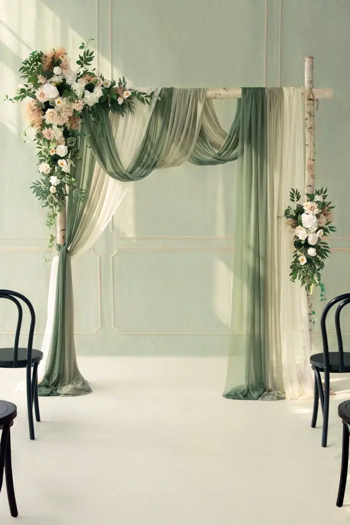 Floral draped wedding altar under greenery canopy