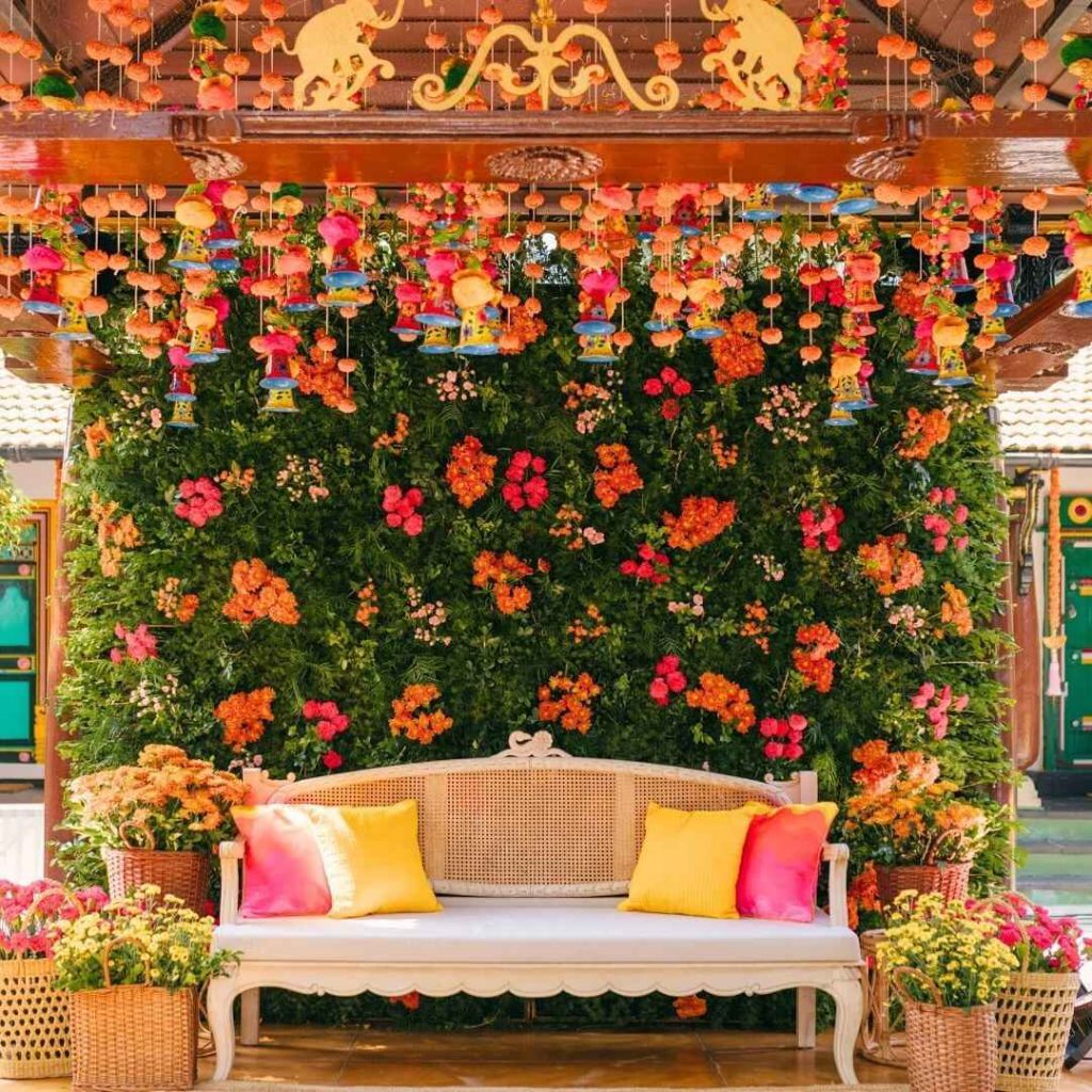 Colorful floral backdrop with hanging decorations above white sofa