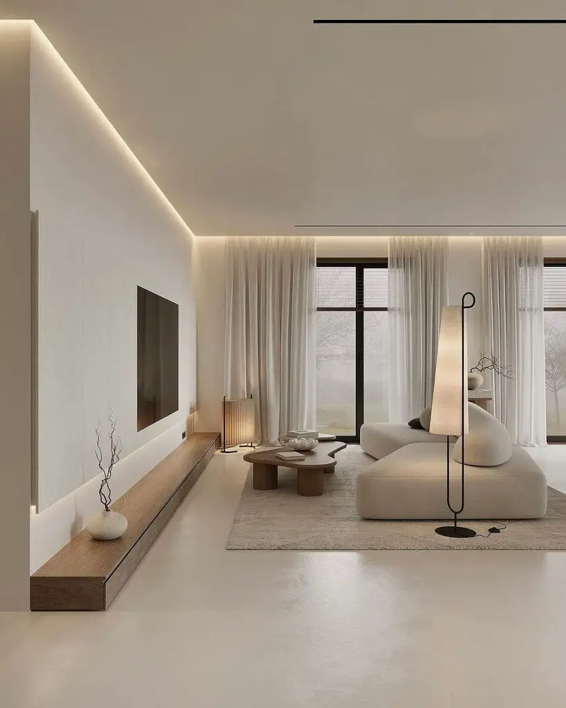 Minimalist living room with curved white sofa, wooden coffee tables, and ambient lighting.