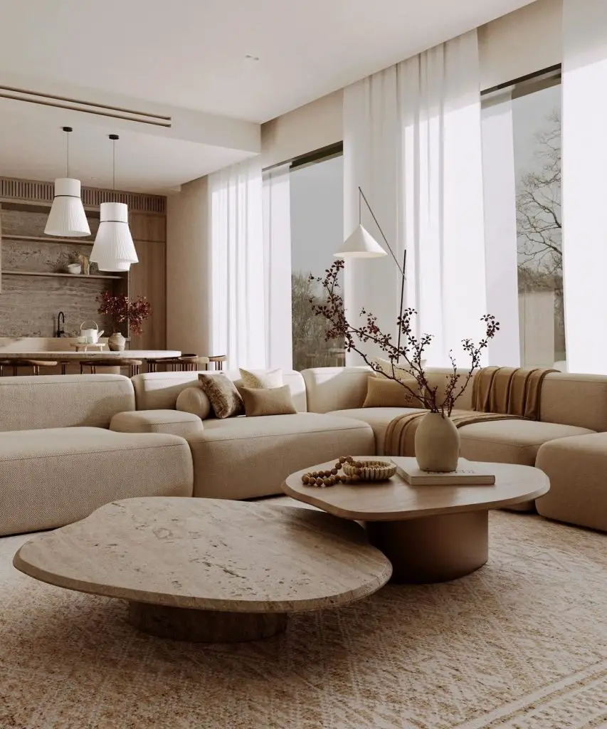 Minimalist living room with curved sofa and stone coffee tables.