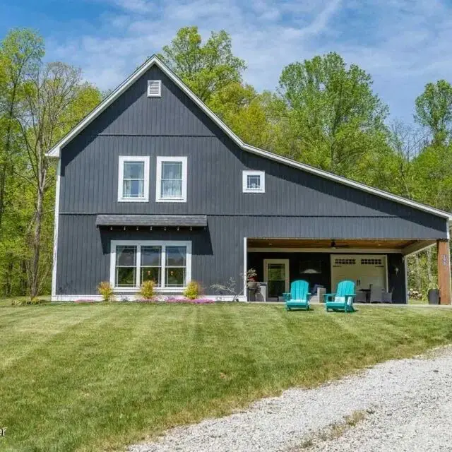 Dark gray barn home with covered outdoor lounge