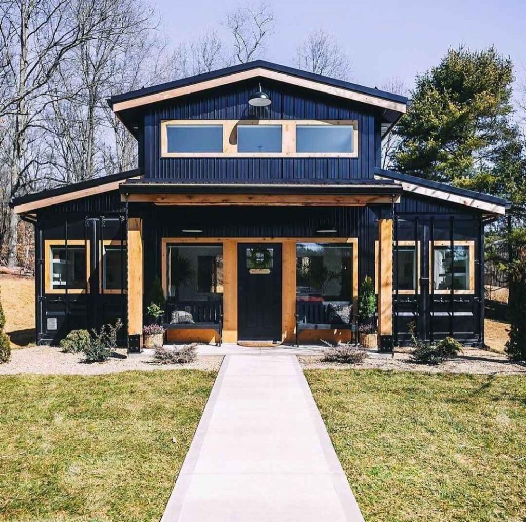 Modern black barnhouse with cedar accents and concrete walkway featuring clerestory windows