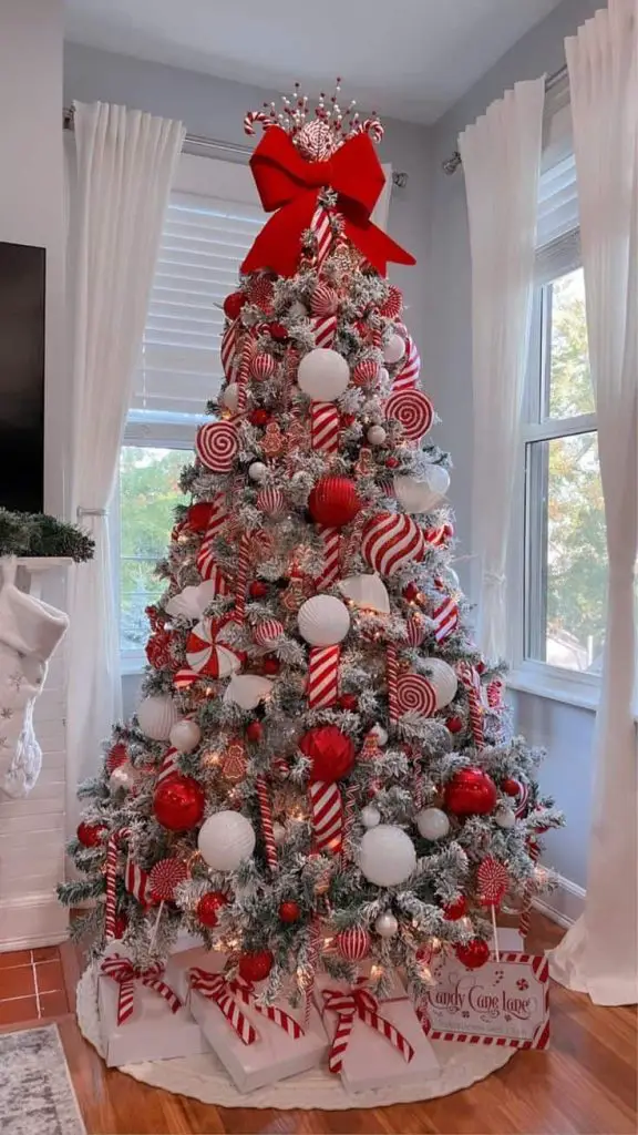 Flocked Christmas tree with red and white candy cane theme decorations