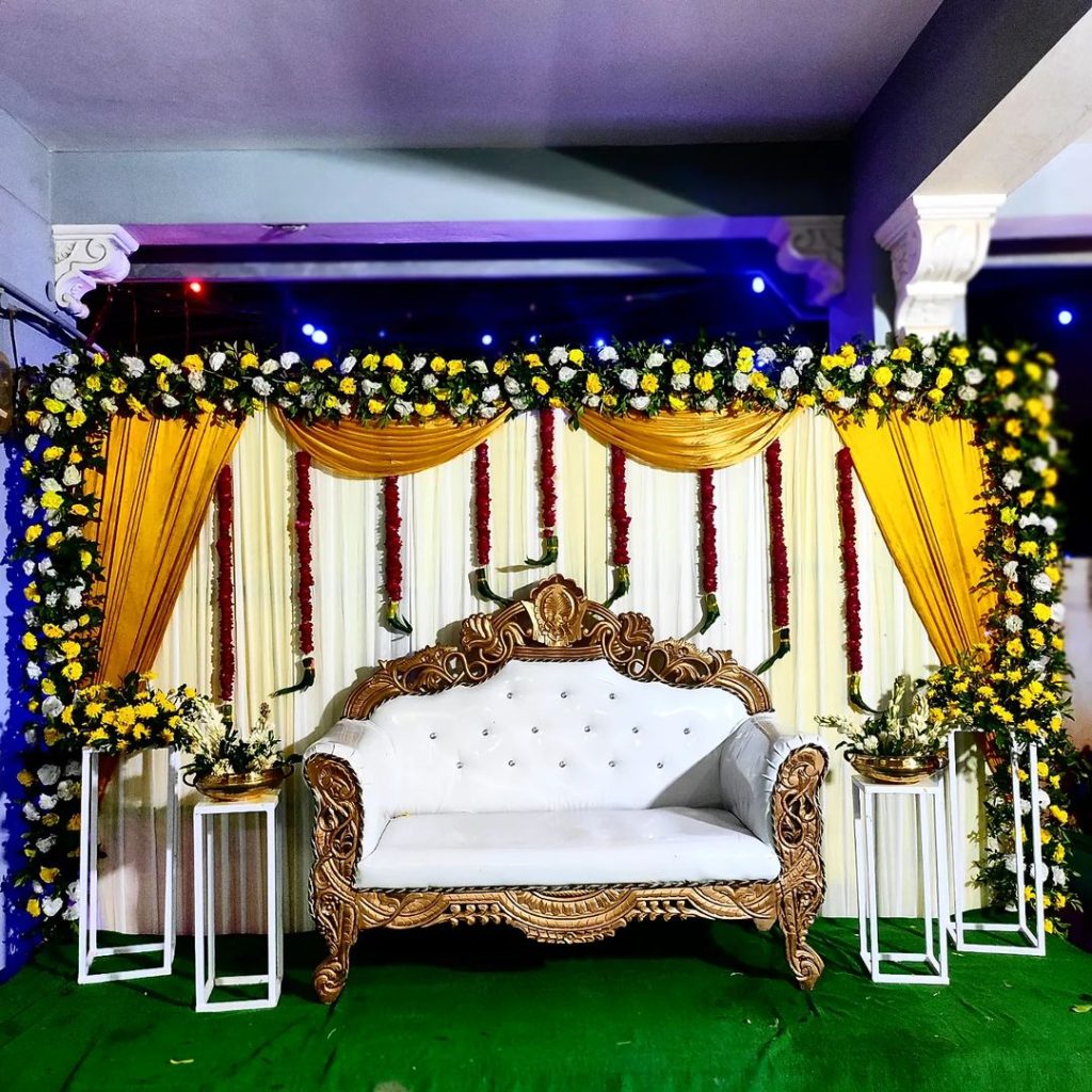 Ornate wedding stage with golden decor and floral arrangements