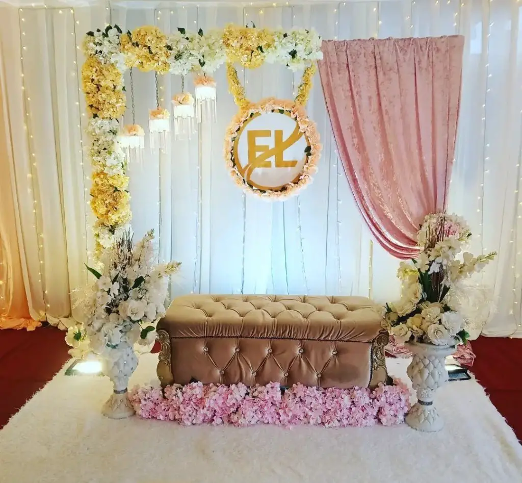 Floral engagement backdrop with monogram and velvet settee