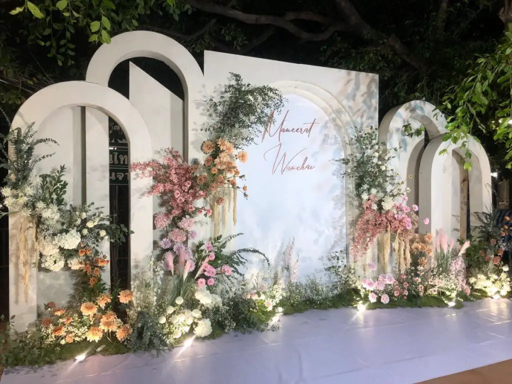 Flower-draped white arch backdrop for wedding ceremonies