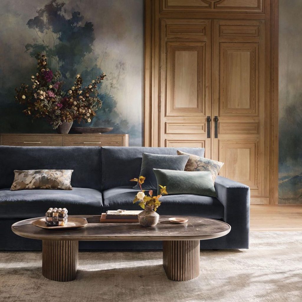 Elegant living room with moody landscape mural and navy sofa