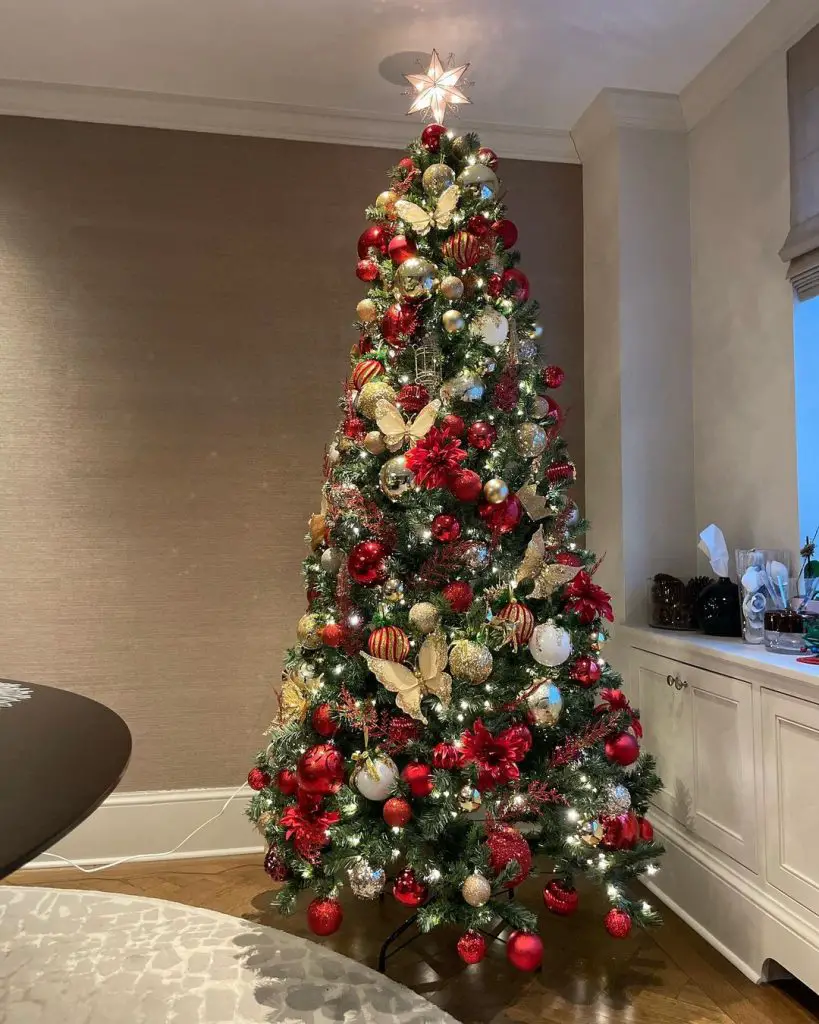 Elegant Christmas tree with gold butterflies and red ornaments