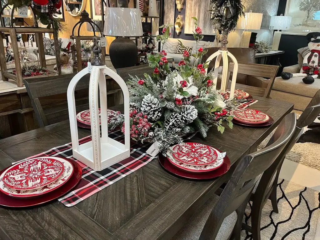 Festive table with pinecone centerpiece and lanterns.