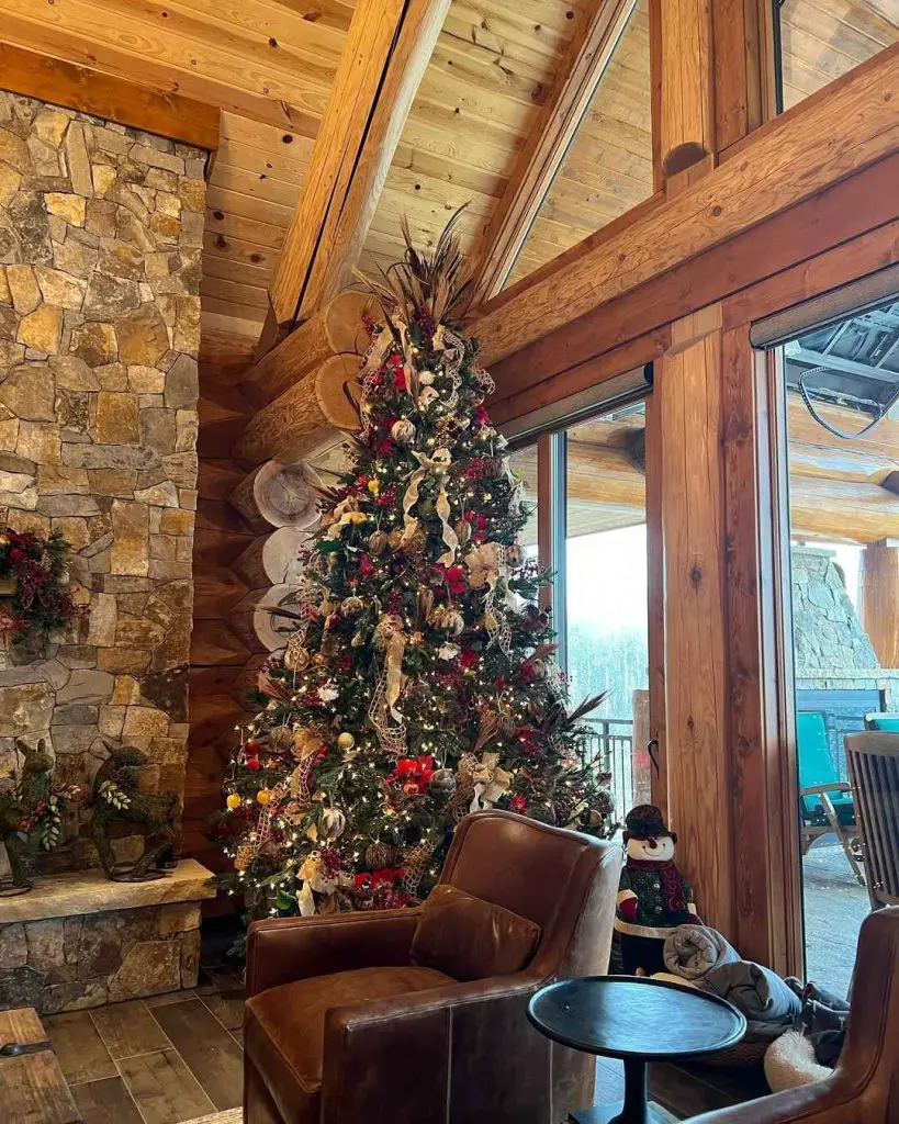 Christmas tree in rustic cabin with stone fireplace
