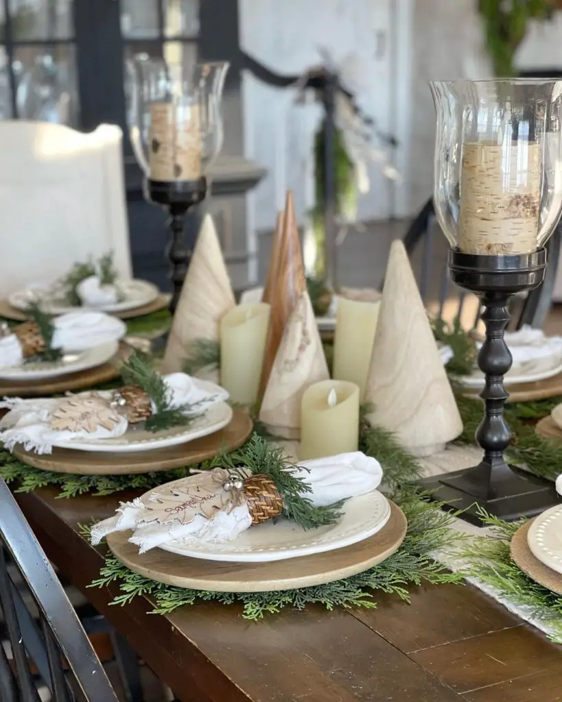 Rustic Christmas table with wooden cone trees, candles, and evergreen decor