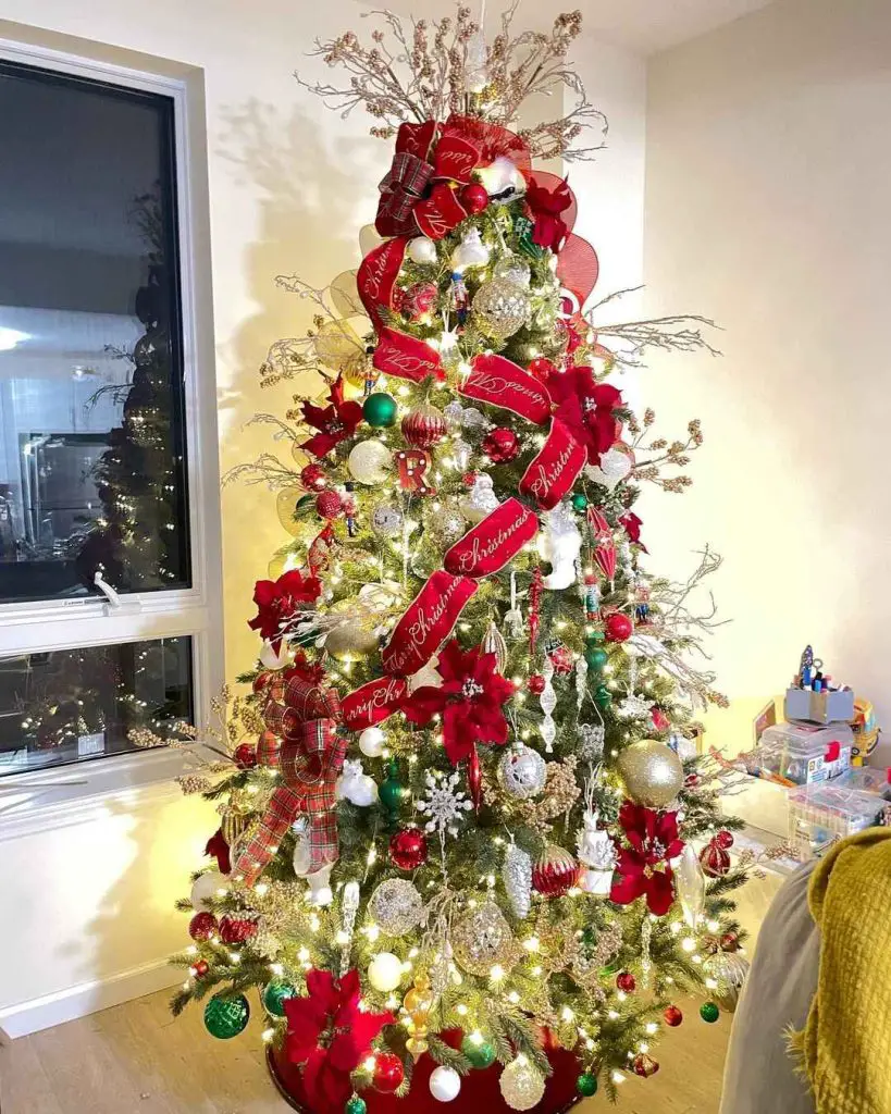 Christmas tree adorned with scripted red ribbons silver ornaments and emerald accents