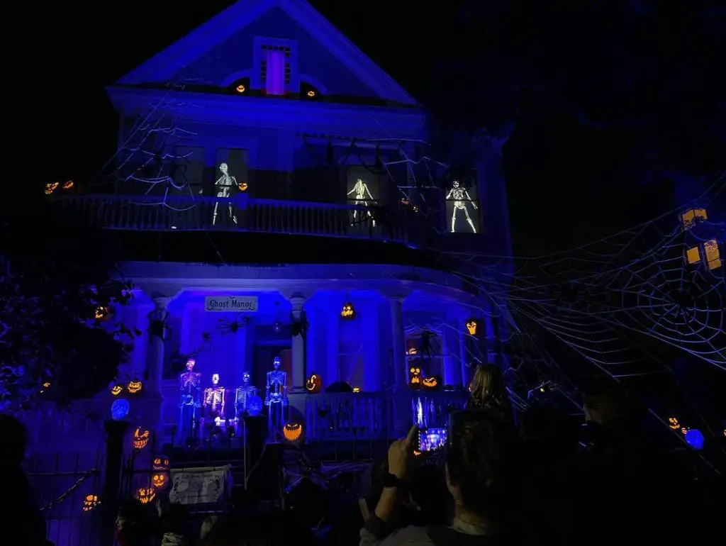 Blue-lit house with glowing skeletons and cobwebs