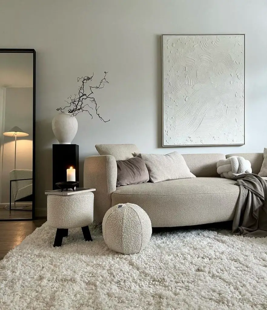 Minimalist beige living room with textured art and mirror.